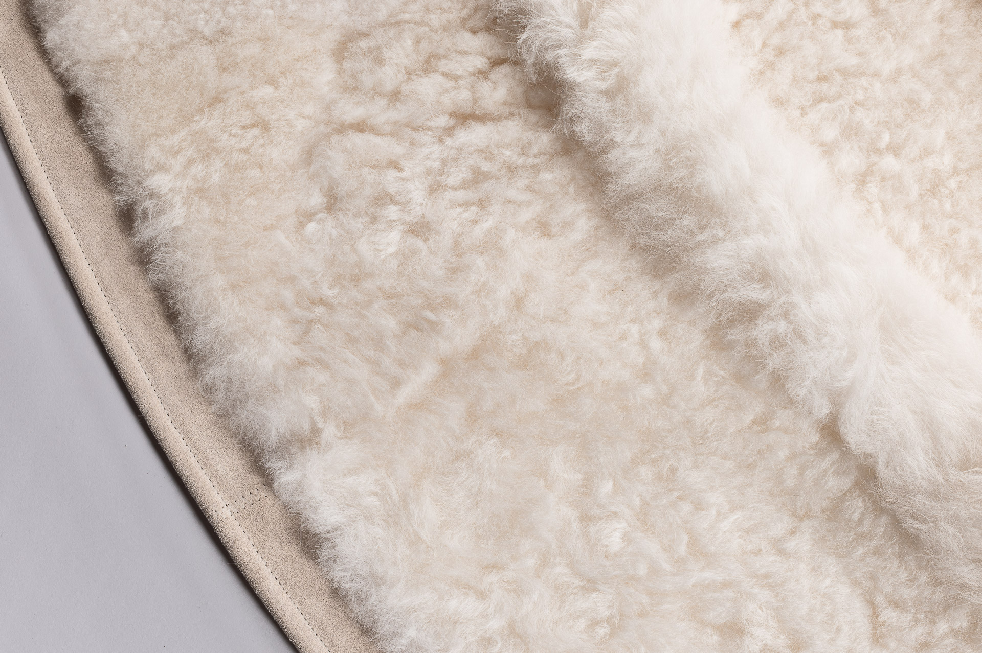Jolie ganse en cuir pour ce tapis rond entièrement doublé fabriqué en France, des finitions haut-de-gamme