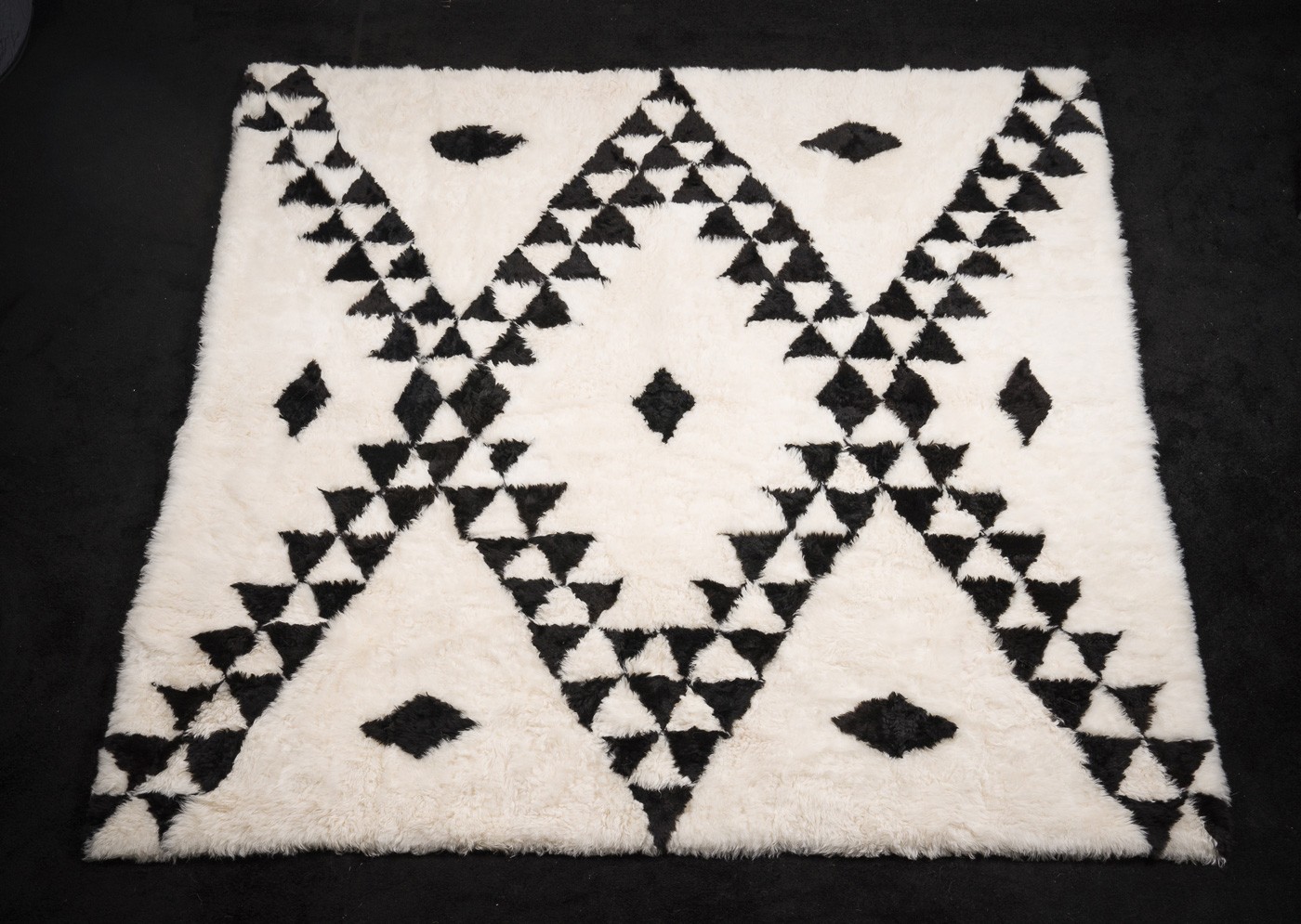 Le tapis Berbère en mouton affiche un parti-pris assumé, mettant en avant des motifs berbères symboliques. Ces motifs traditionnels sont tissés depuis des générations en Afrique du Nord, où la domestication du mouton joue un rôle clé dans l'art du tapis berbère.