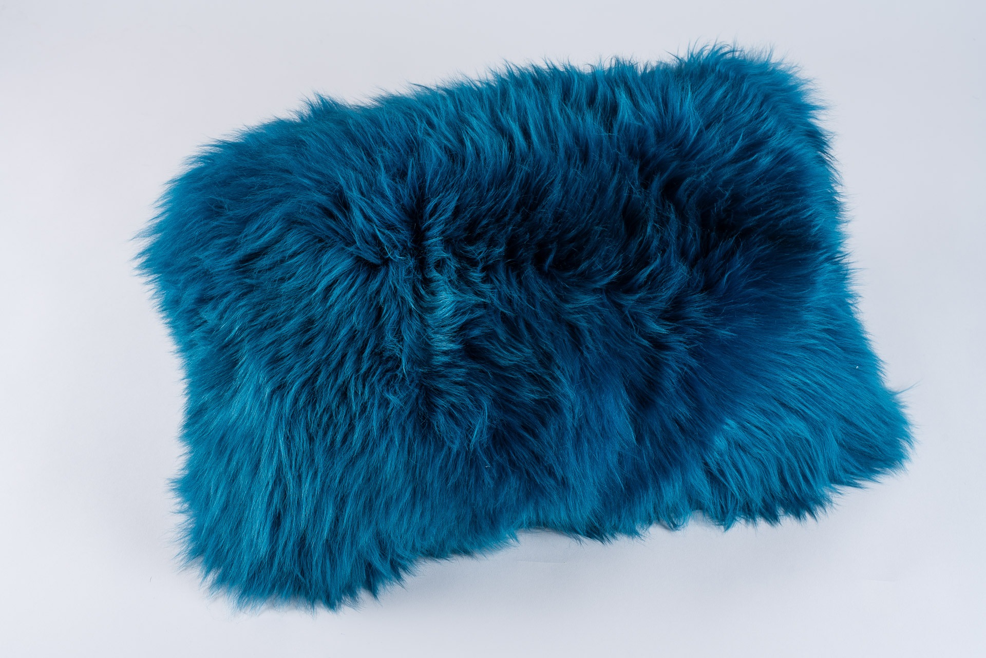 Coussin rectangle en peau de mouton bleu outremer. Un coloris chaud parfait pour décorer un joli salon ou une chambre d'un chalet de montagne.