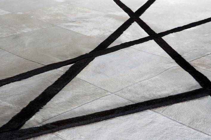 Des finitions haute-couture pour notre tapis Oslo en peau de vache blanche et mouton noir fabriqué sur-mesure dans de nombreux coloris. Nous pouvons dessiner et concevoir votre tapis exclusif sur simple demande.