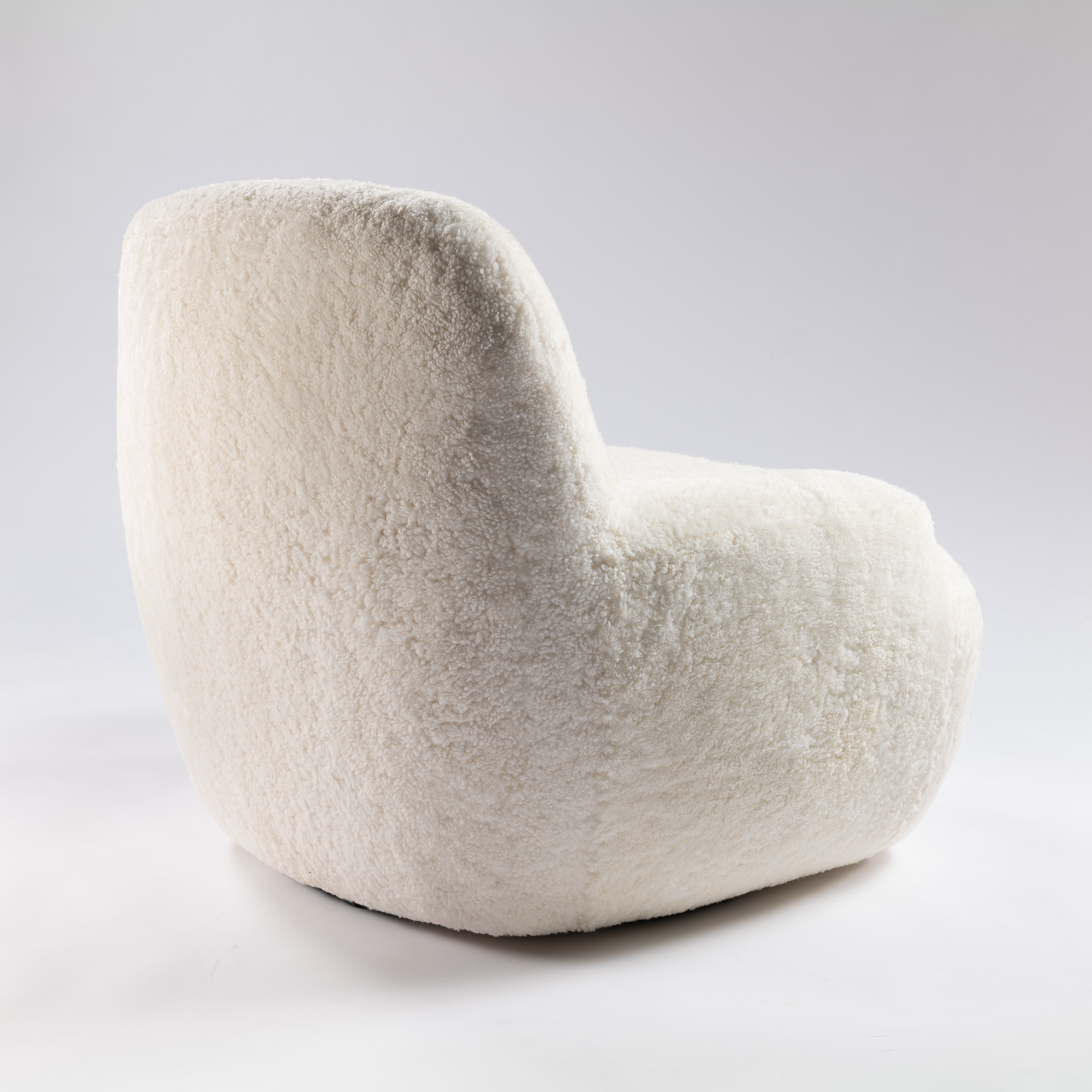 Petit fauteuil moelleux et accueillant blanc en mouton ou agneau au design contemporain et au très grand confort.