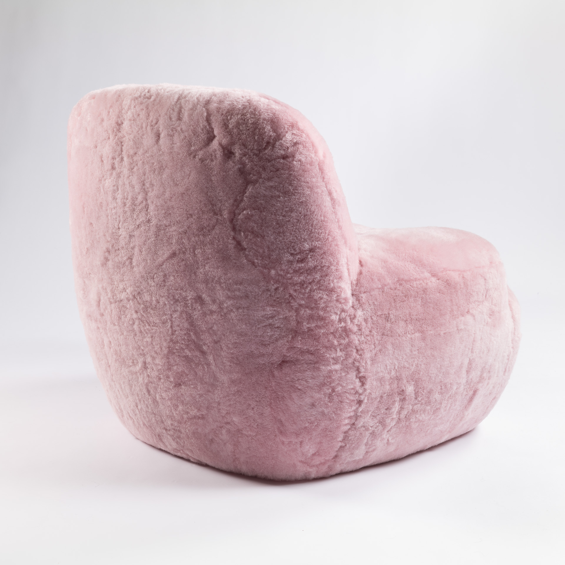 Vue de dos de ce petit fauteuil rose layette au design moderne et élégant.