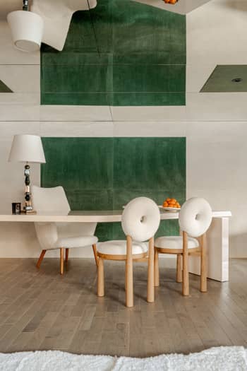 Espace bureau dans notre showroom de Gstaad. Revêtement en cuir nubuck vert émeraude et blanc avec fauteuil vintage Mama Bear de Hans Wegner.