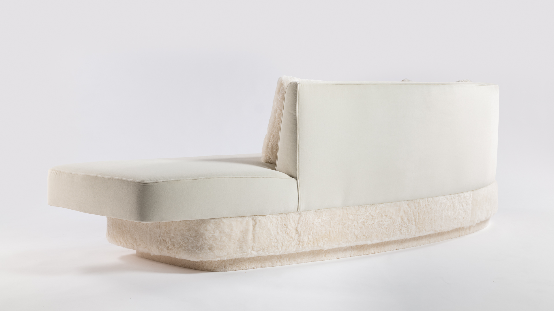 Dossier arrondi, ligne épurée pour ce canapé blanc en velours et agneau. Une pièce d'exception pour une décoration d'intérieur recherchée