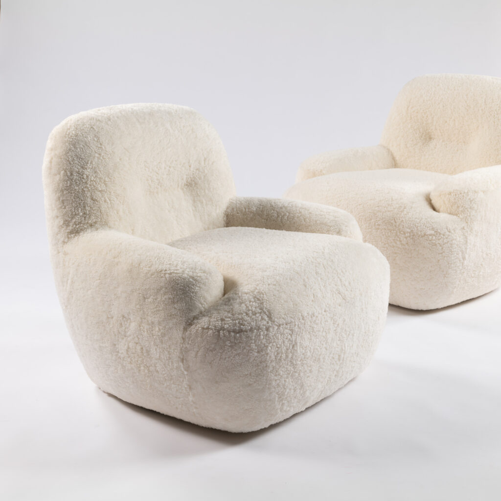 Petits fauteuils de salon ou de chambre à coucher design et contemporain de forme arrondie sur socle pivotant à 360° et recouvert de peau de mouton blanche, rose poudré ou marron
