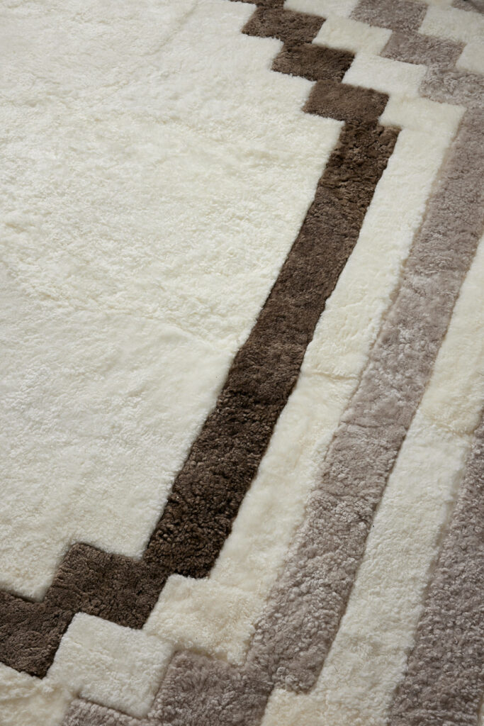 Tapis en mouton curly rasé, blanc, beige et marron. Le luxe d'un tapis sur-mesure intégralement doublé et fabriqué en France. Un tapis carré très graphique et parfait pour la décoration de le salon de votre chalet à Gstaad ou la chambre de votre appartement à Monaco.